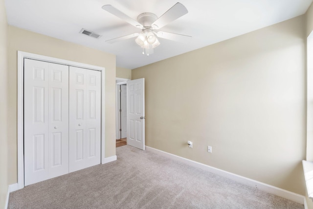 unfurnished bedroom featuring carpet floors, a closet, visible vents, and baseboards