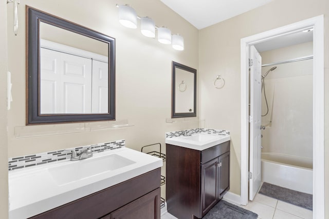 bathroom with tile patterned flooring, tasteful backsplash, bathtub / shower combination, and a sink