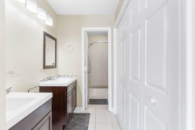 bathroom featuring tile patterned flooring, shower / tub combination, two vanities, and a sink