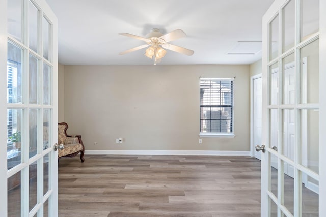 unfurnished room featuring french doors, baseboards, and wood finished floors