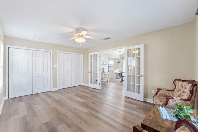 interior space with french doors, visible vents, light wood-style flooring, a ceiling fan, and baseboards