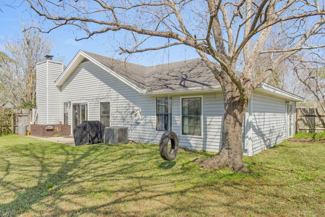 back of property with a patio, central AC, fence, a yard, and a chimney