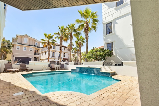 community pool with a patio, a jacuzzi, and fence