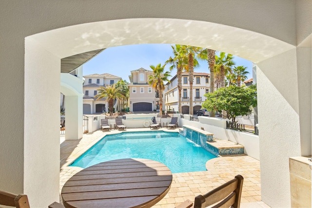 view of pool with a patio area, a hot tub, a residential view, and a fenced in pool