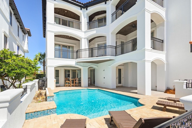 rear view of house featuring french doors, a patio, stucco siding, fence, and an outdoor pool