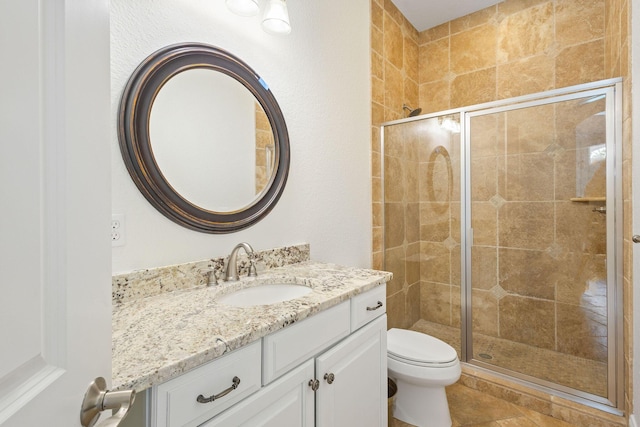 bathroom with toilet, a stall shower, and vanity