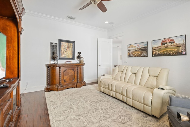 living area featuring baseboards, visible vents, hardwood / wood-style floors, and ornamental molding