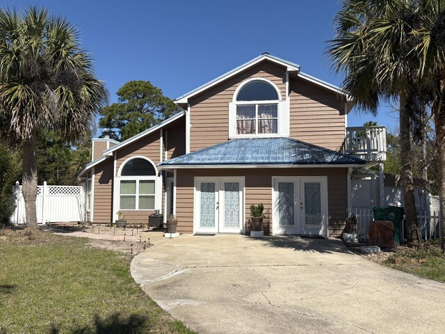 view of front of property with a front yard, french doors, fence, and metal roof