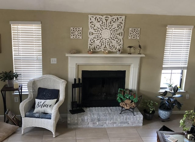 living room featuring tile patterned flooring and a brick fireplace