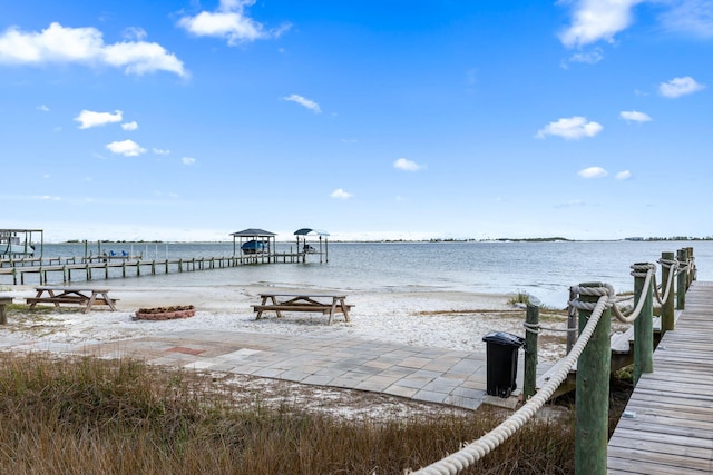 dock area with a water view and a view of the beach