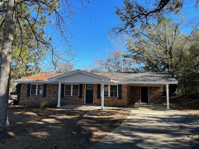 single story home featuring a carport, concrete driveway, and brick siding