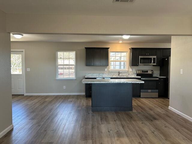 kitchen featuring stainless steel appliances, plenty of natural light, light countertops, and a center island