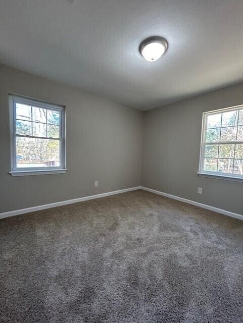 carpeted empty room with baseboards