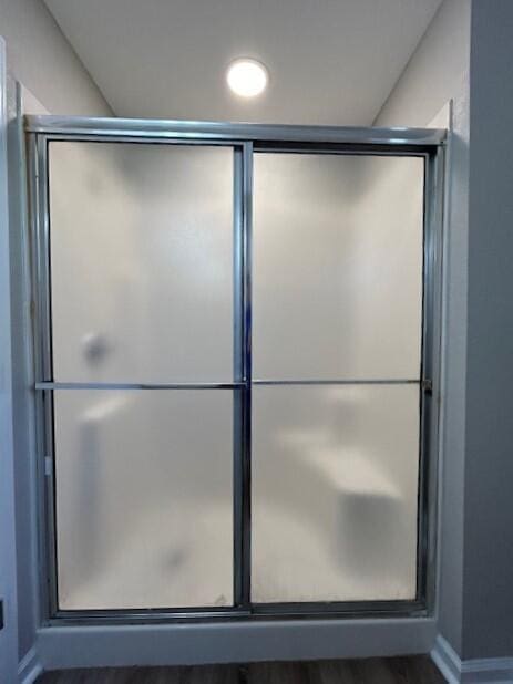 full bathroom featuring a shower stall and baseboards