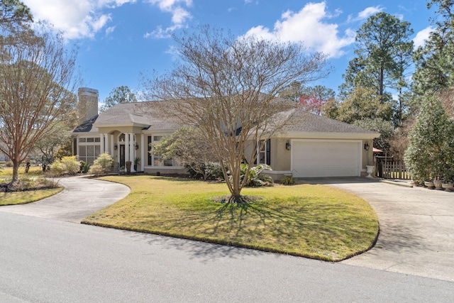 view of front of home featuring a front lawn, stucco siding, a chimney, a garage, and driveway