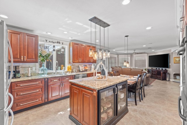 kitchen featuring beverage cooler, a sink, hanging light fixtures, stainless steel appliances, and open floor plan