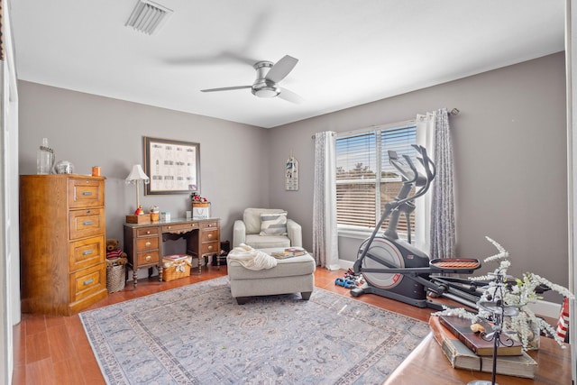 sitting room featuring visible vents, ceiling fan, and wood finished floors