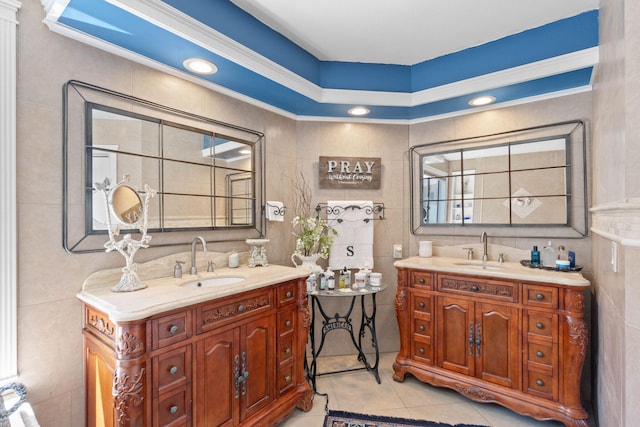 bathroom featuring tile walls, two vanities, and a sink