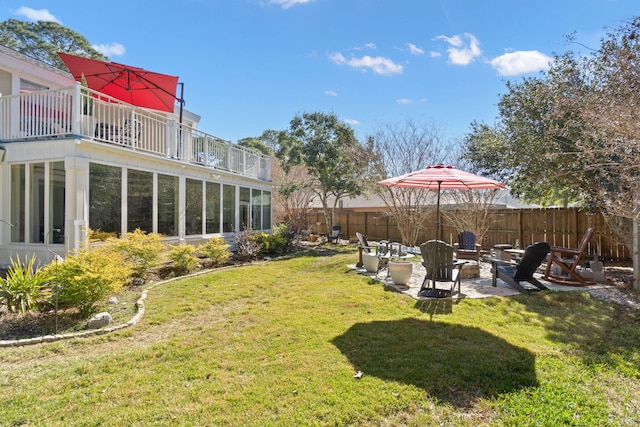 view of yard with a patio area, an outdoor fire pit, a balcony, and fence