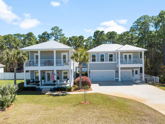 view of front of home featuring a garage, covered porch, a balcony, and fence