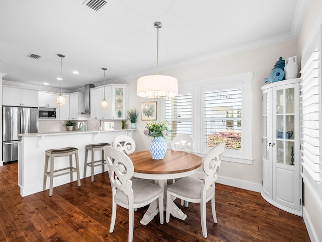 dining space with visible vents, ornamental molding, and dark wood finished floors