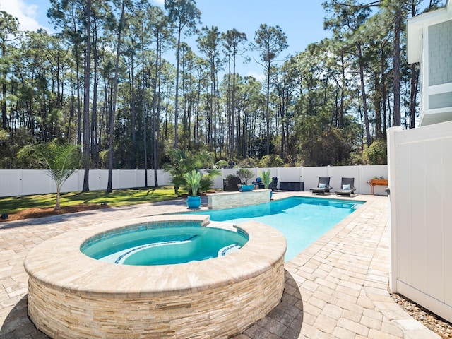 view of swimming pool with a patio, a fenced backyard, and a pool with connected hot tub