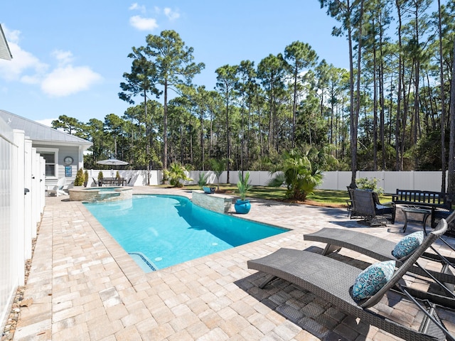 view of pool with a patio area, a pool with connected hot tub, and a fenced backyard