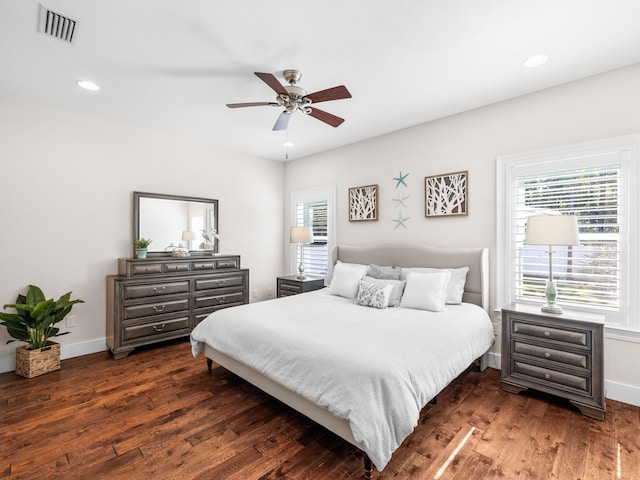 bedroom with multiple windows, dark wood-style floors, and visible vents