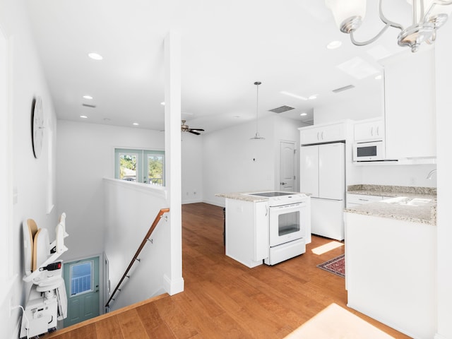 kitchen featuring visible vents, light wood-style flooring, a sink, white appliances, and white cabinets