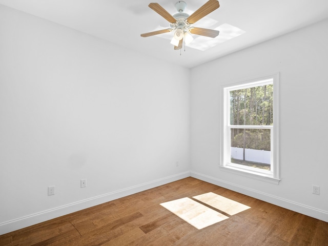 unfurnished room with a ceiling fan, baseboards, and wood finished floors