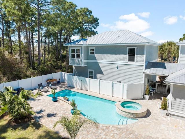 view of swimming pool with a gate, a patio, a fenced backyard, and a pool with connected hot tub