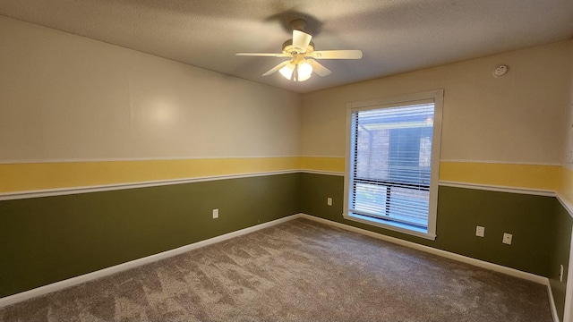 carpeted spare room featuring a ceiling fan, a textured ceiling, and baseboards