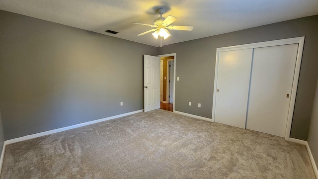 unfurnished bedroom featuring baseboards, a closet, visible vents, and carpet flooring