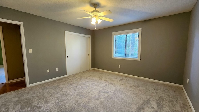 unfurnished bedroom featuring a textured ceiling, carpet floors, and a closet