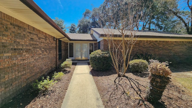 entrance to property featuring french doors and brick siding