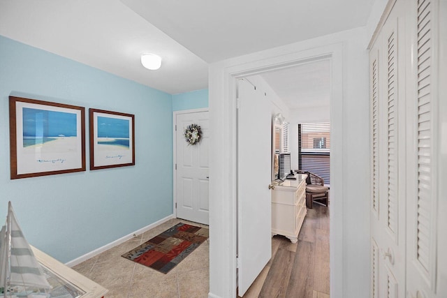 foyer entrance with baseboards and wood finished floors