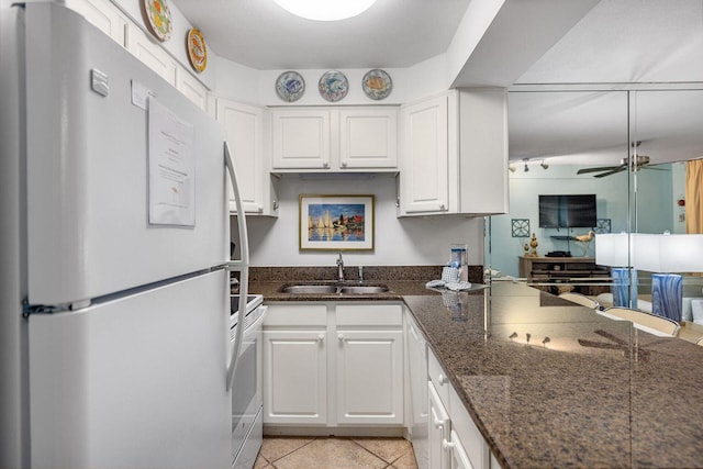 kitchen featuring light tile patterned floors, ceiling fan, white appliances, a sink, and white cabinets