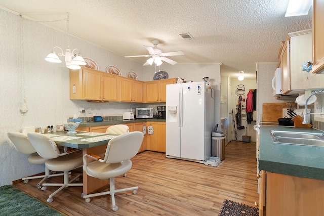 kitchen with white appliances, visible vents, dark countertops, light wood-style flooring, and a sink