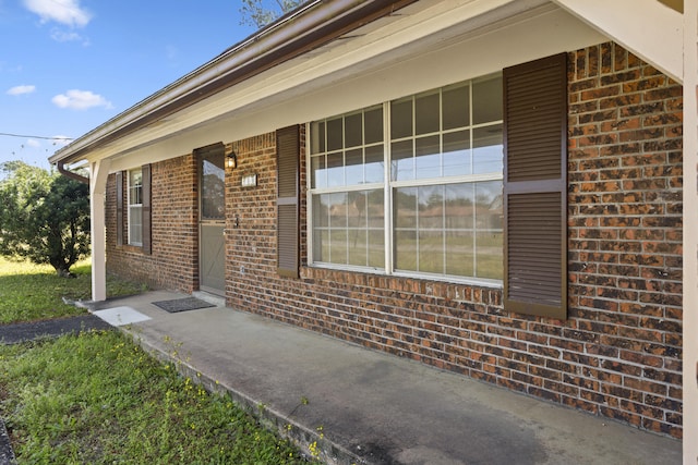 view of exterior entry featuring brick siding