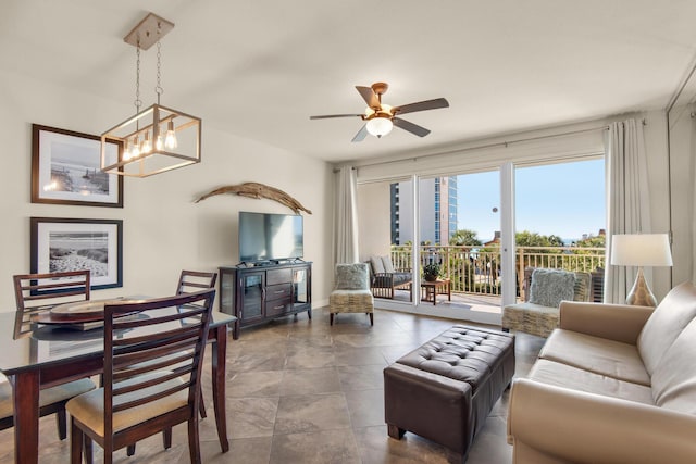 living area featuring ceiling fan with notable chandelier