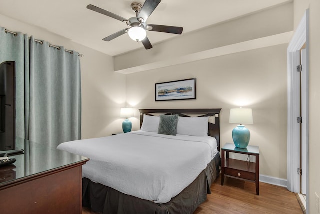 bedroom featuring ceiling fan, baseboards, and wood finished floors