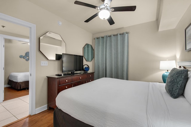 bedroom with ceiling fan, baseboards, and wood finished floors