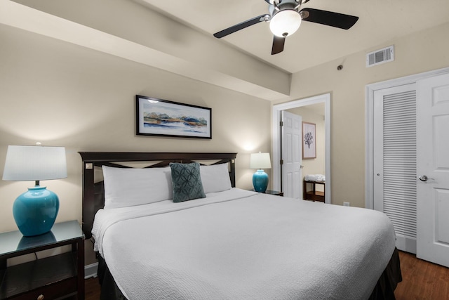 bedroom with a closet, visible vents, dark wood finished floors, and ceiling fan