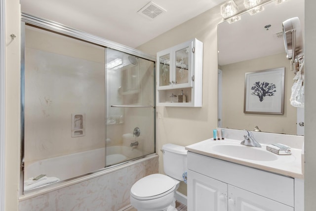 bathroom with visible vents, vanity, toilet, and bath / shower combo with glass door