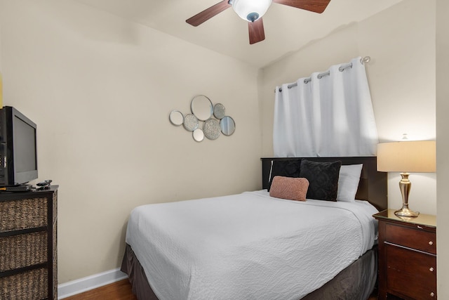 bedroom featuring ceiling fan, baseboards, and wood finished floors