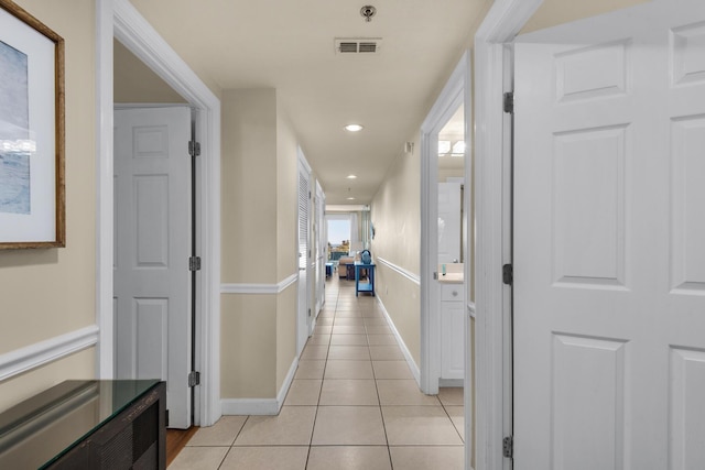 hall featuring light tile patterned floors, baseboards, visible vents, and recessed lighting