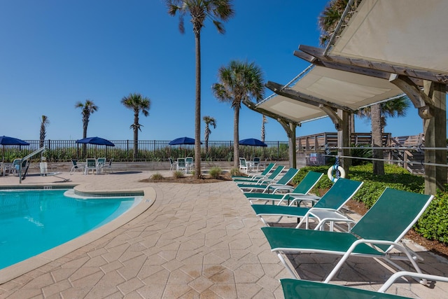 pool with a patio and fence