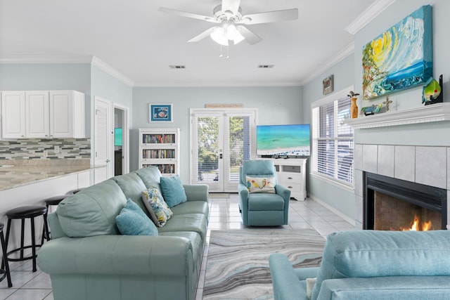 living area featuring light tile patterned floors, plenty of natural light, a fireplace, and visible vents