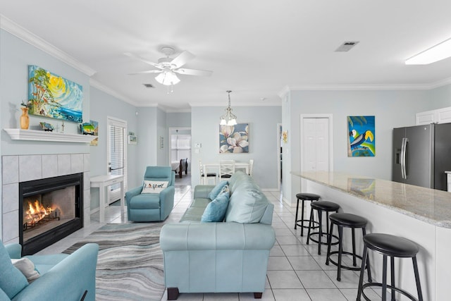 living area with light tile patterned floors, ornamental molding, a fireplace, and visible vents