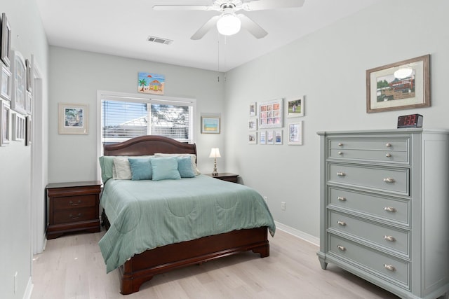 bedroom with light wood-style flooring, visible vents, ceiling fan, and baseboards